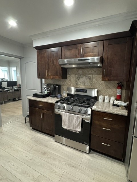 Home kitchen with dark wood cabinets, stainless appliances, and a coffee station