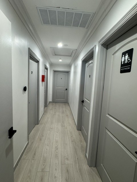 Bright interior hallway with resident doors and an accessible restroom