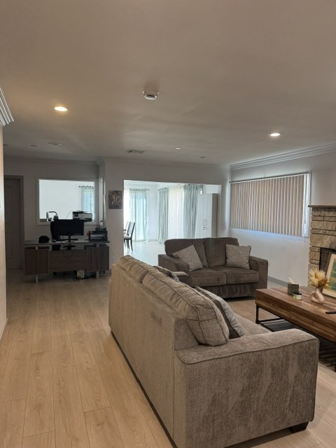 Open living area with light wood floors leading through to the dining room